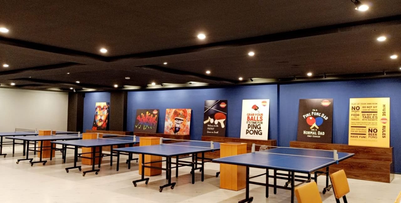 Long view of the tables with posters on the blue wall