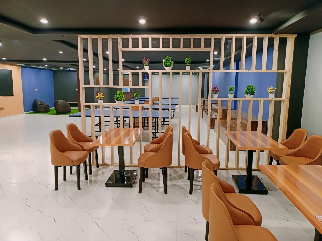 Leather chairs and wooden tables beside the play area