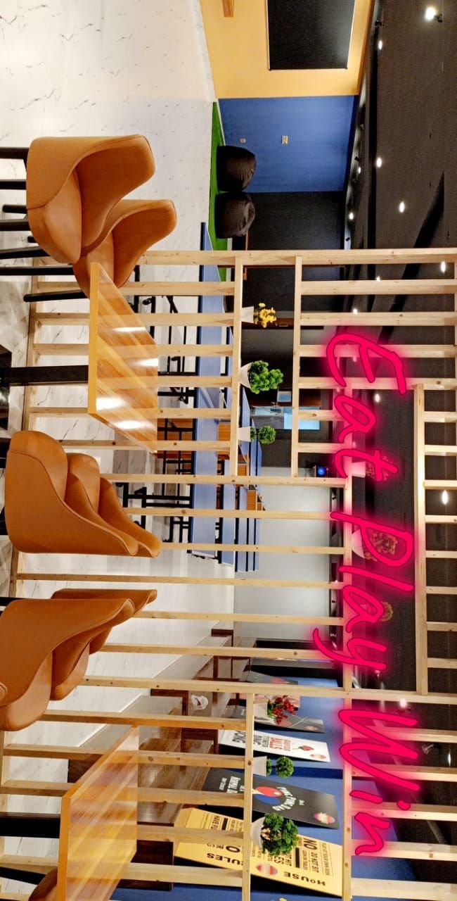 Pink neon sign reading Eat Play Win behind wooden slats